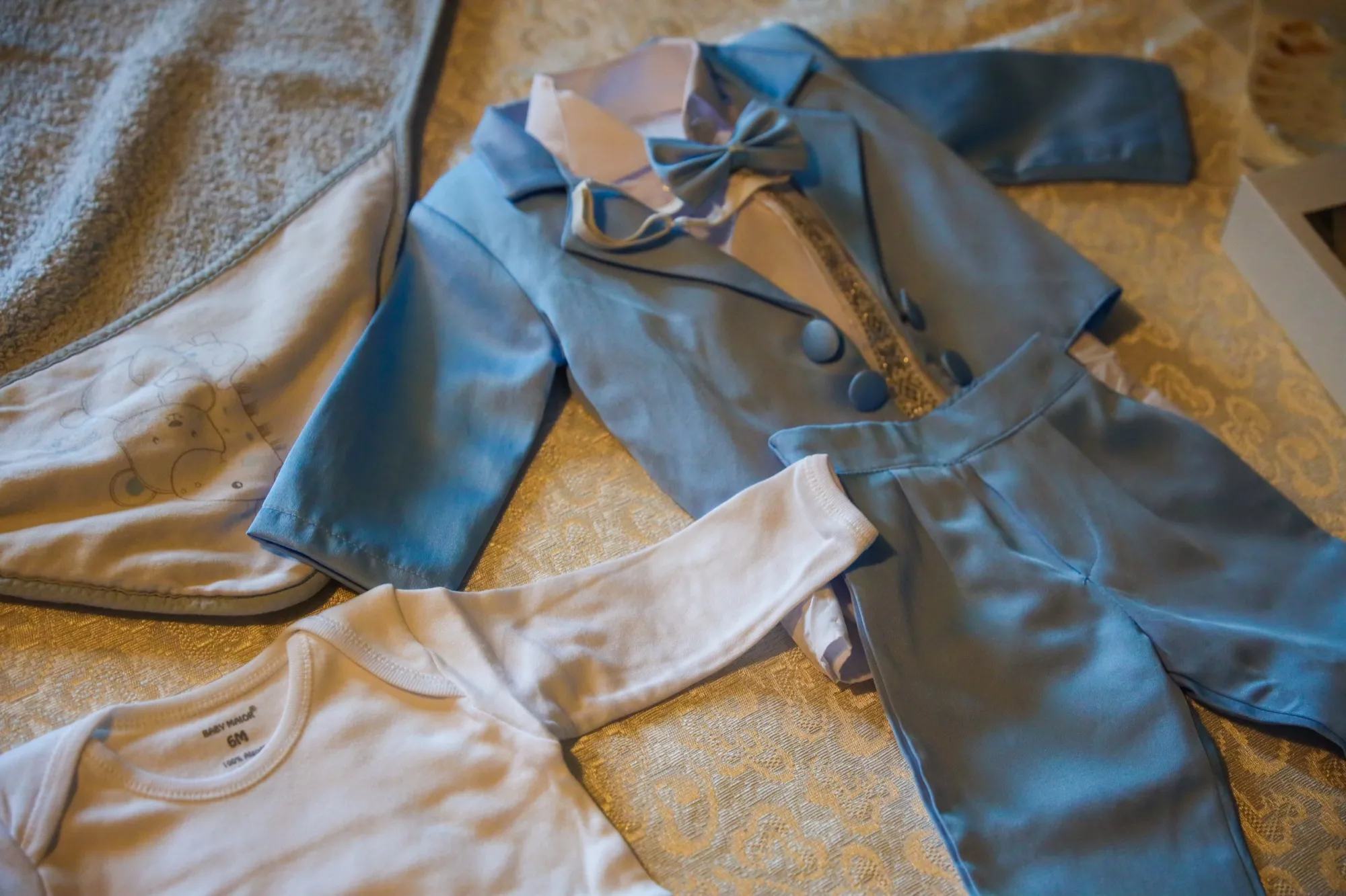 The little blue christening suit, laid out on the bed