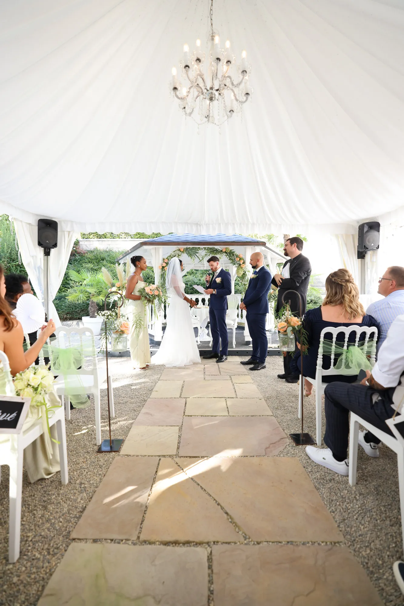 A symbolic ceremony under a white marquee, facing the lake