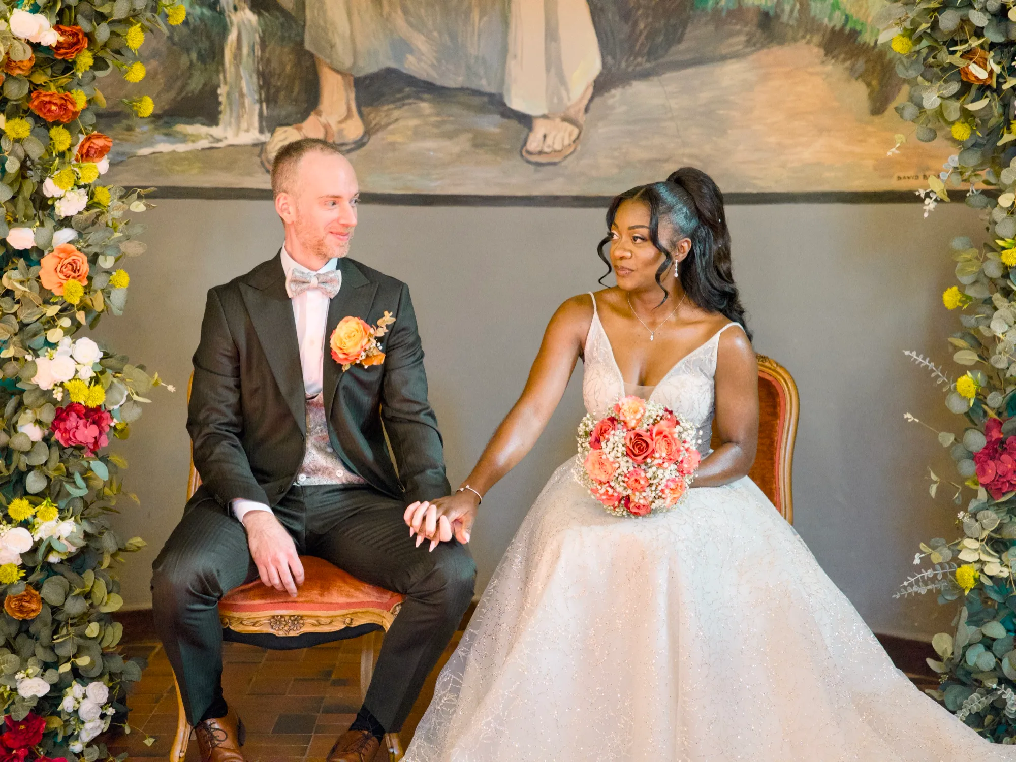 The couple under the flower arch during the ceremony
