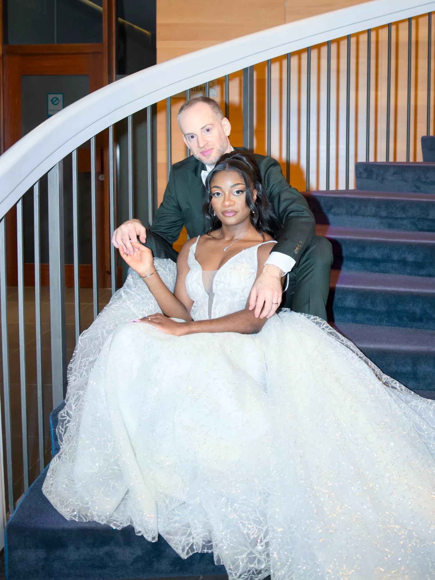 The bride seated on the stairs, her dress spread out