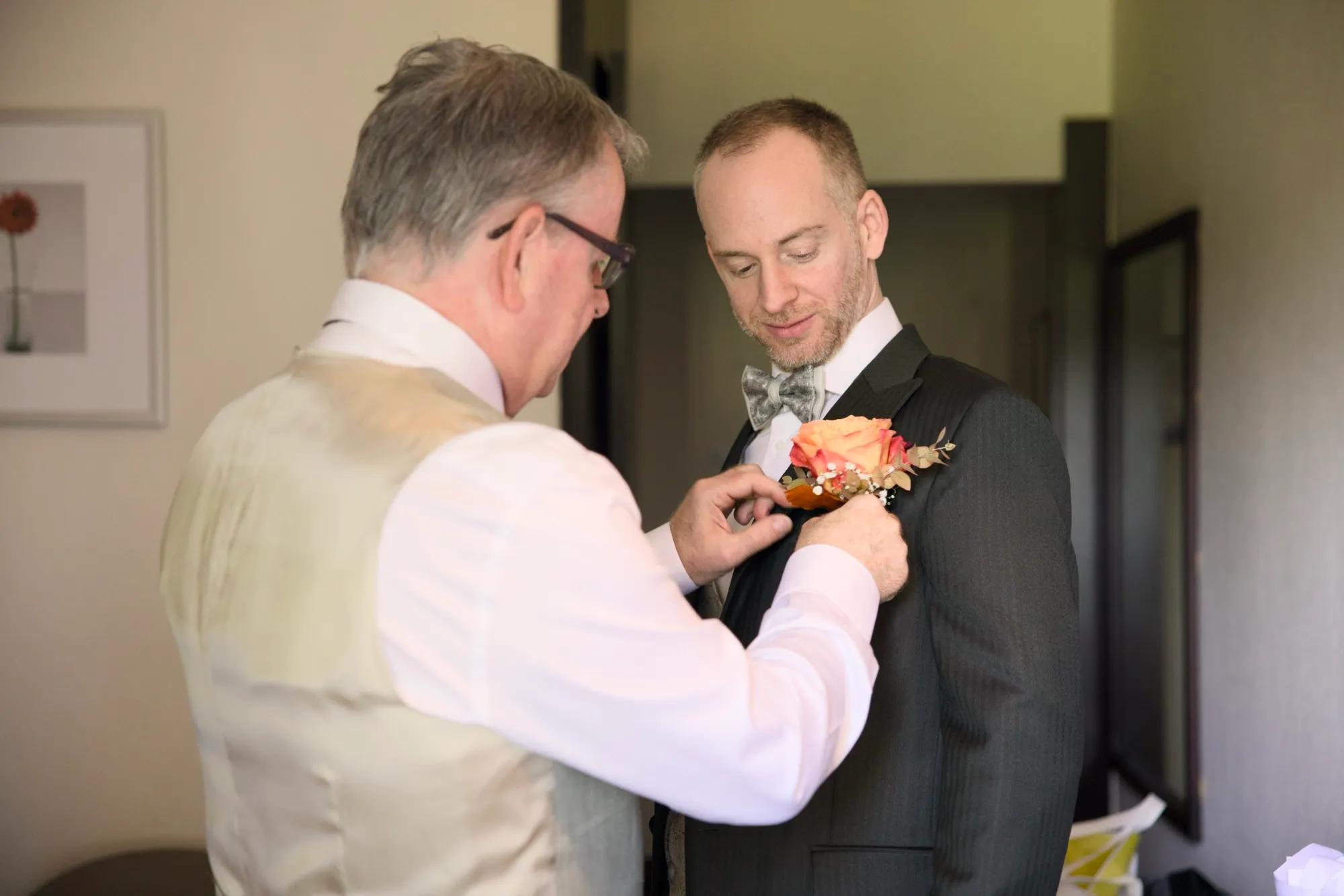 The groom’s father adjusts his buttonhole