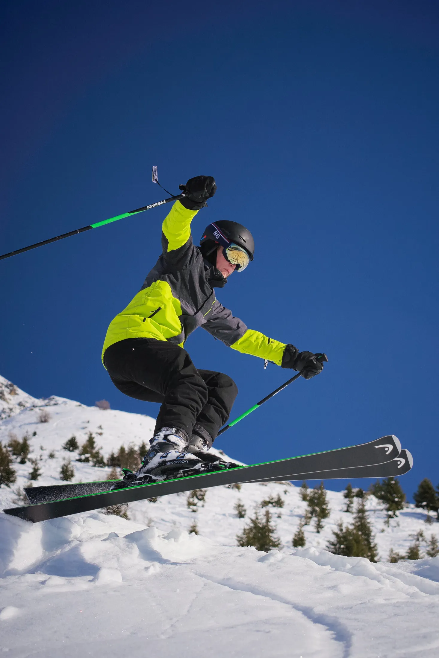 Freeride skier mid-jump against a blue sky