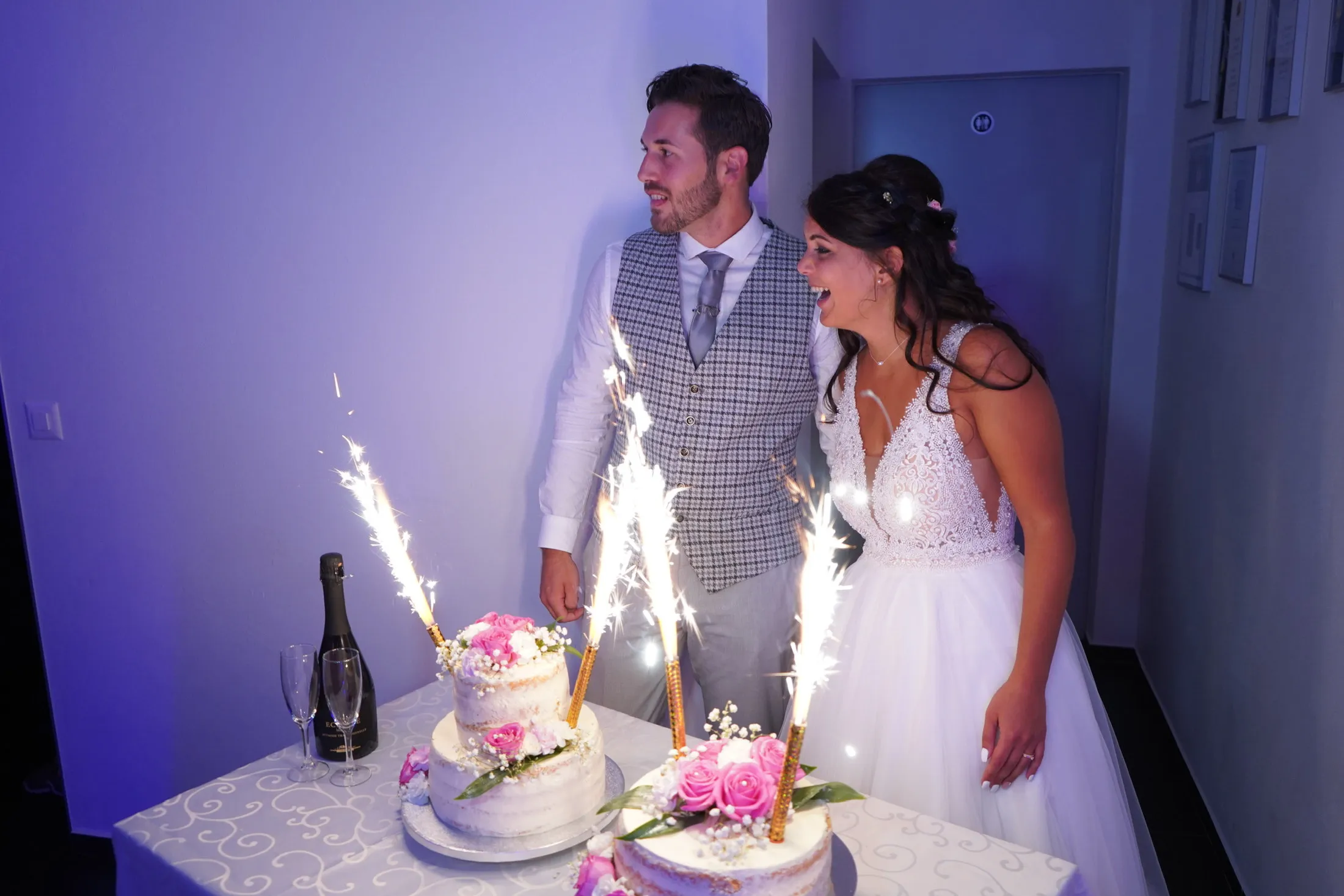 The couple cutting the cake under sparklers
