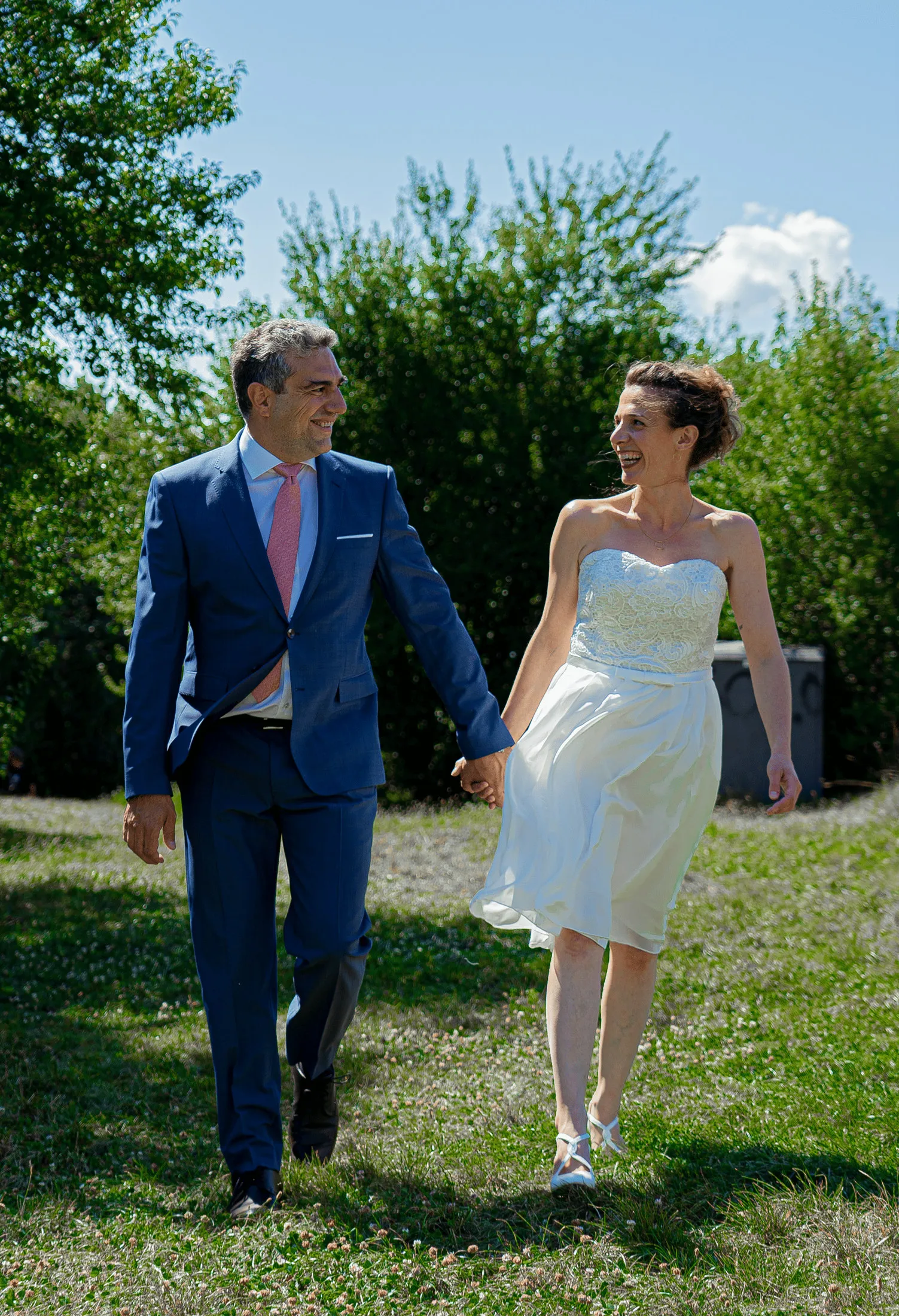 The couple walking hand in hand in a garden