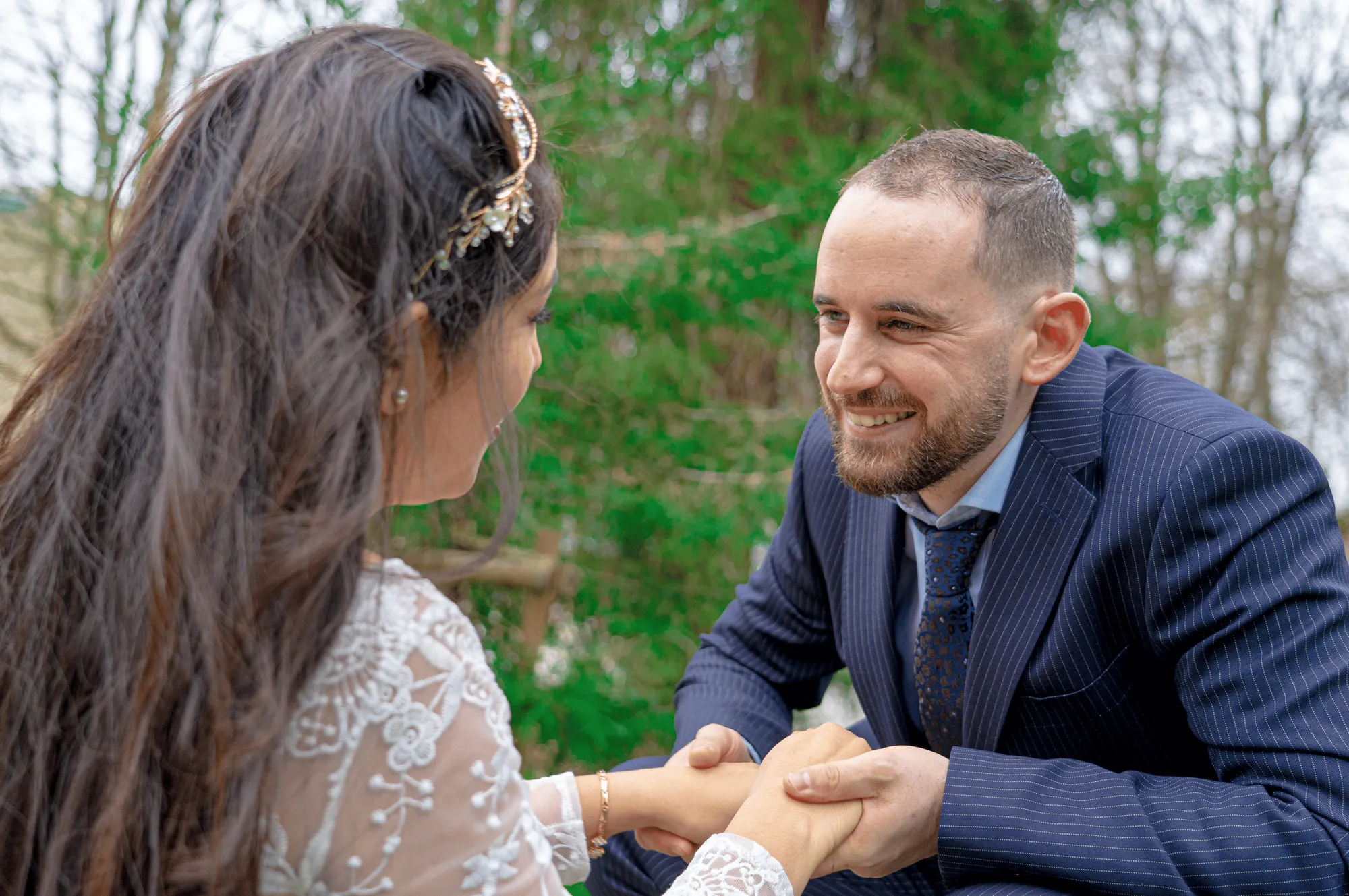 The couple holding hands and smiling at each other