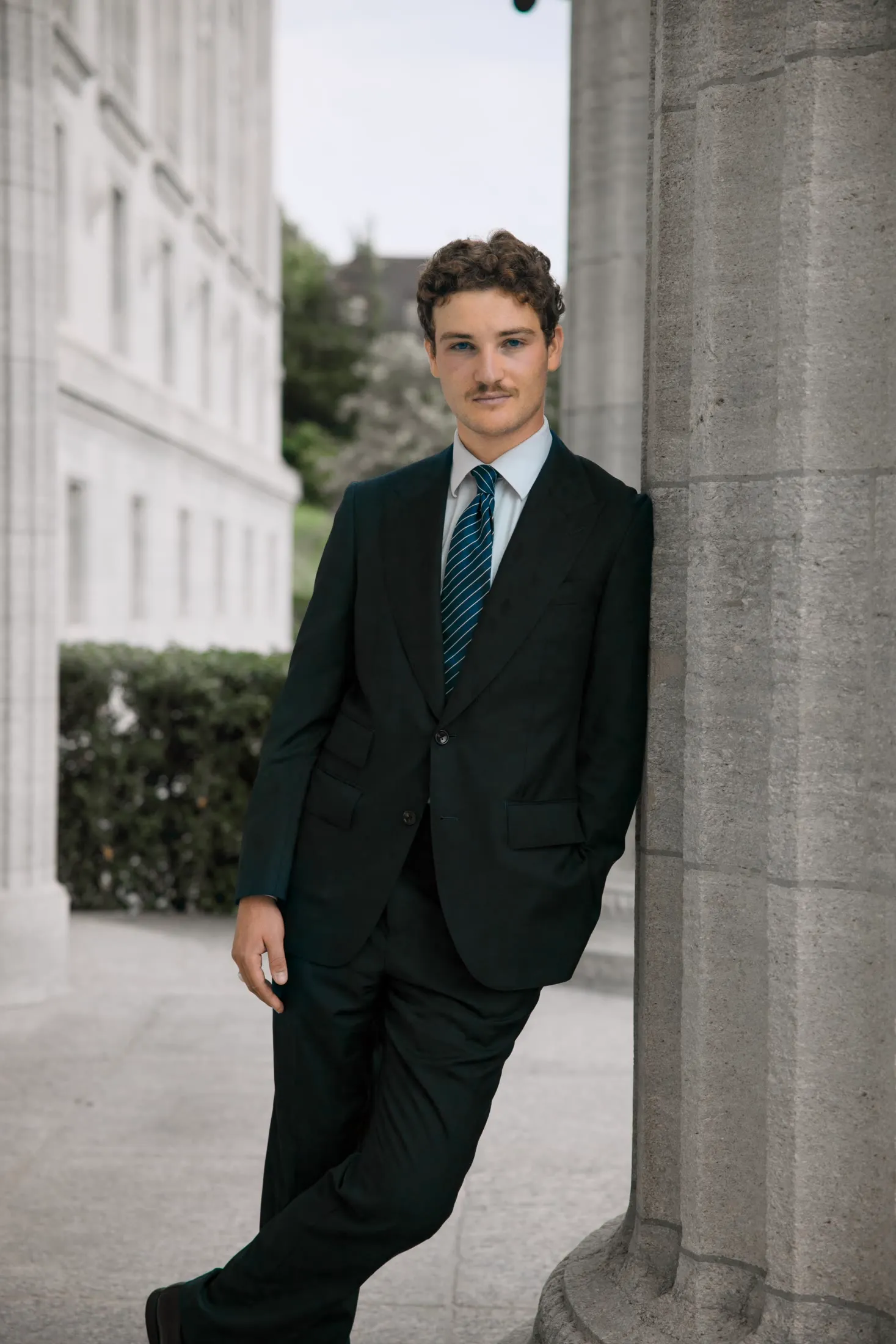 Outdoor business portrait, leaning against a stone column
