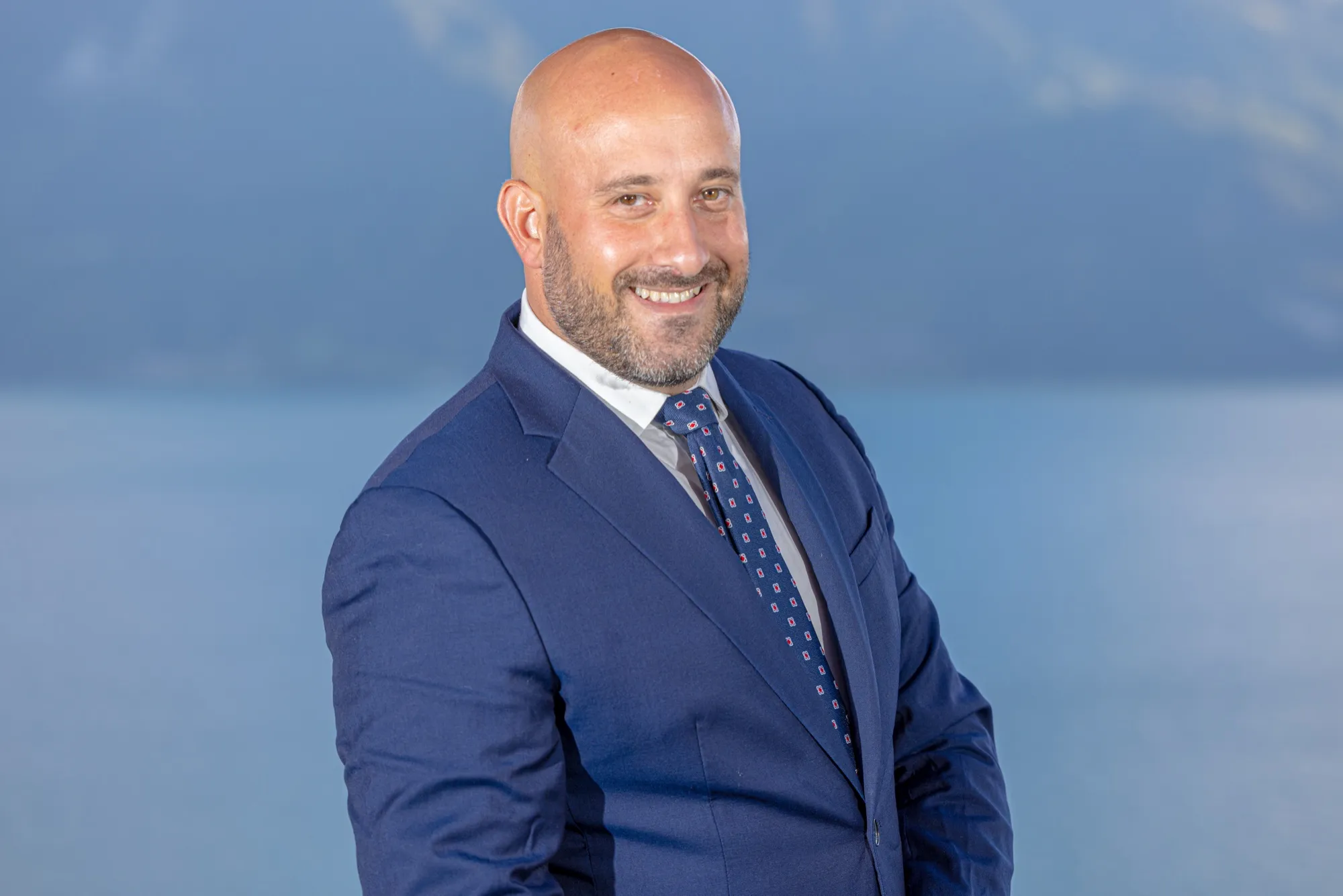 Portrait of a participant in a suit, lake and mountains behind
