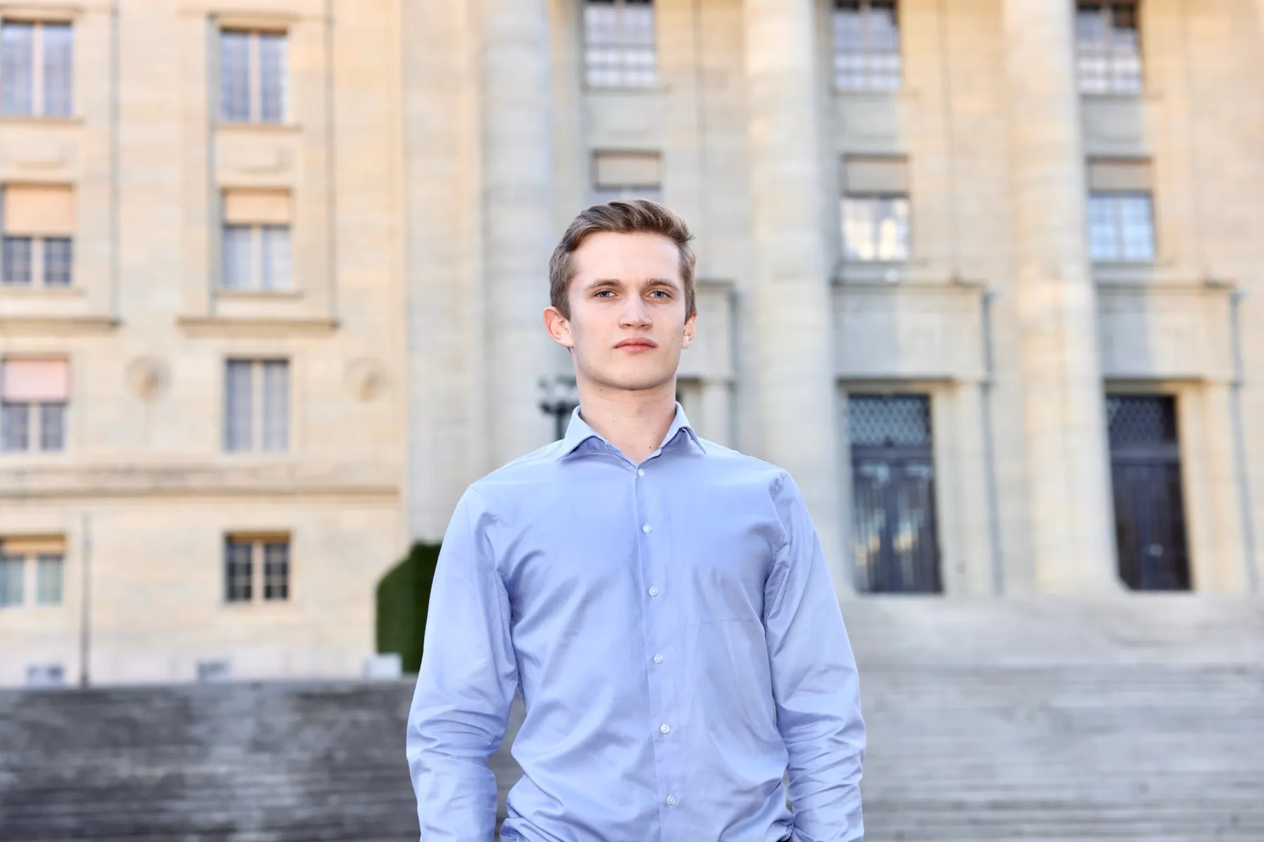 Portrait in a blue shirt in front of a stone façade