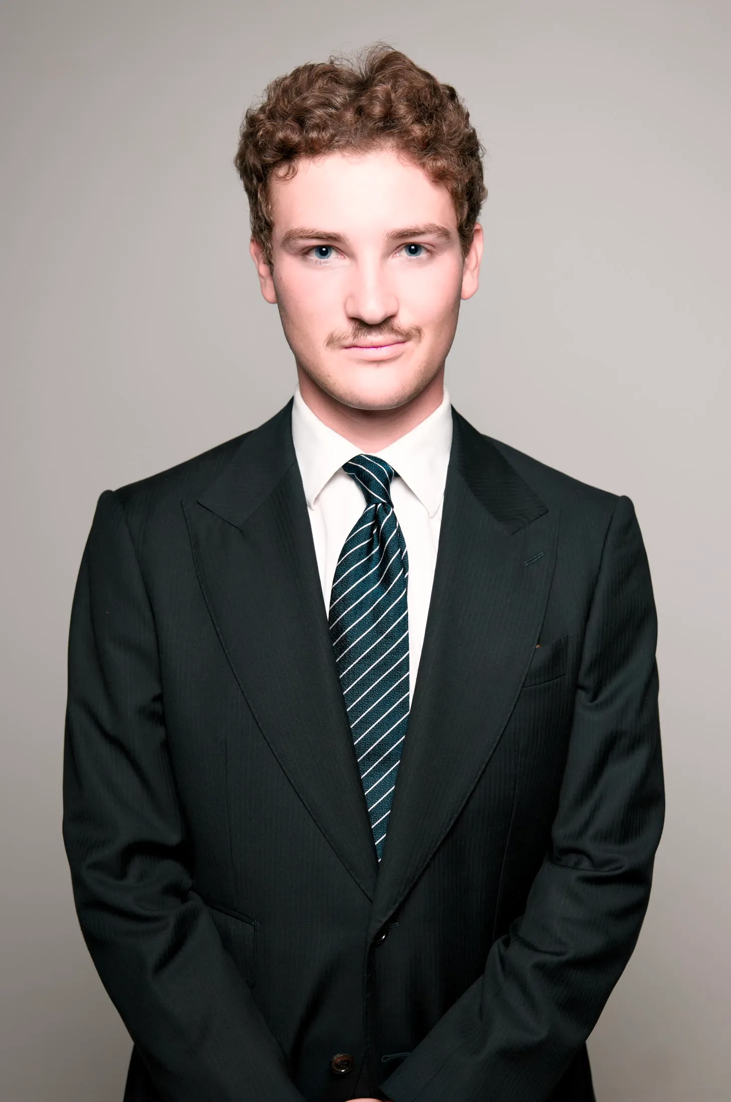 Studio portrait, man in a suit against a grey backdrop