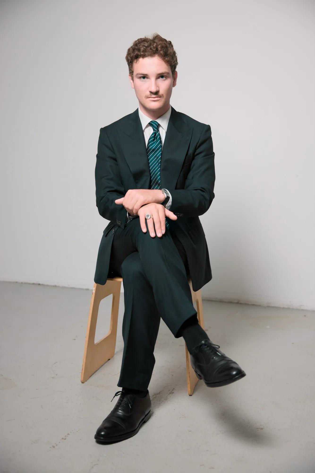 Full-length portrait, seated on a stool in the studio