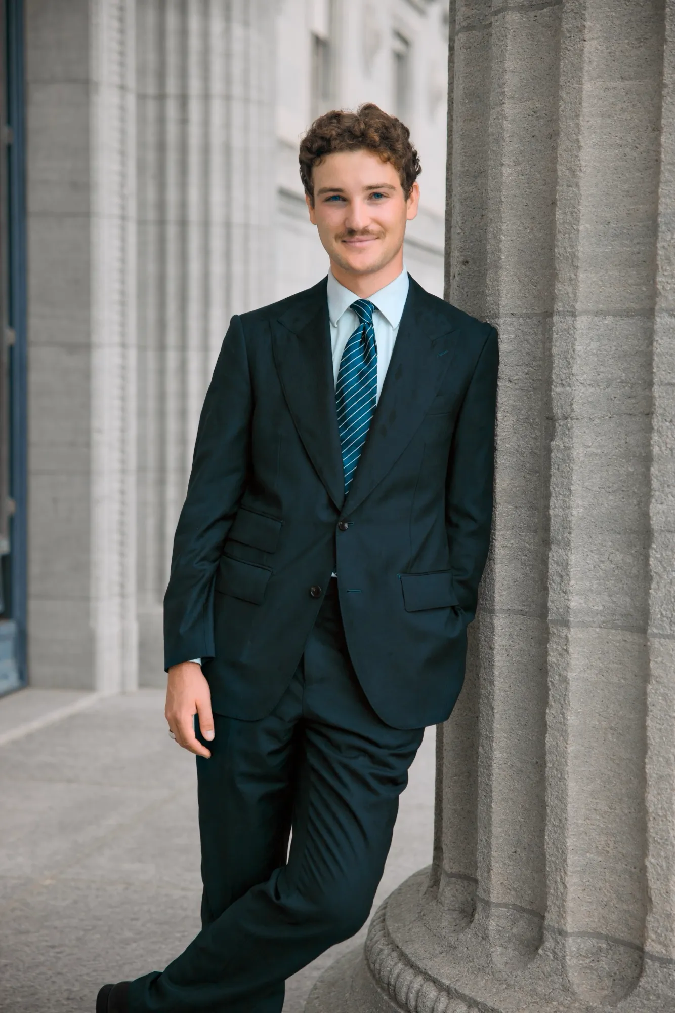 Portrait leaning against a column, outdoors