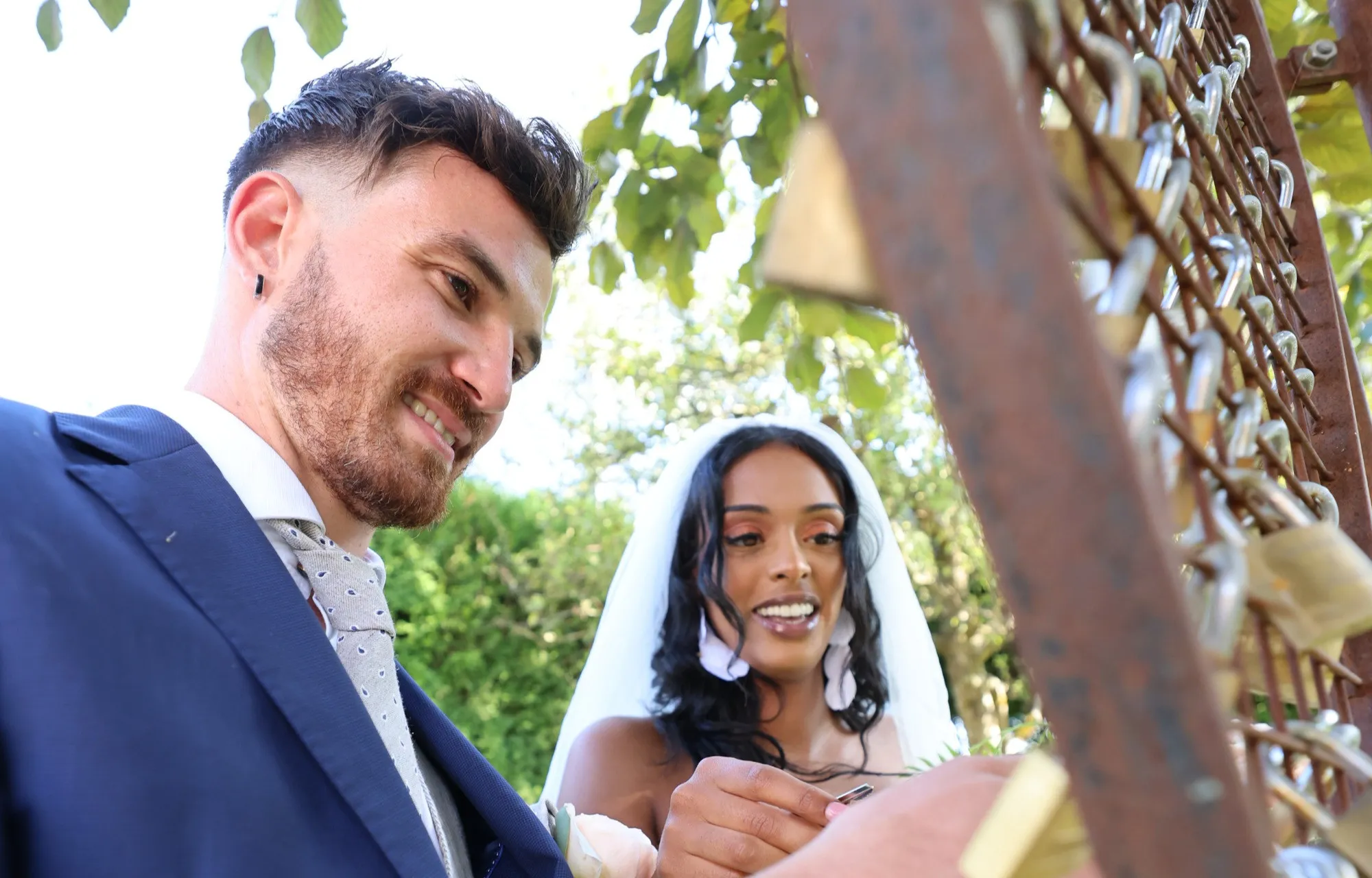 The groom bursts out laughing as the bride looks on